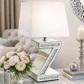 Elegancka lampka na stoliku glamour z lustrem i kwiatami w zbliżeniu.jpg